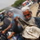 A man sprays people with water on a road in Karachi on May 22.
